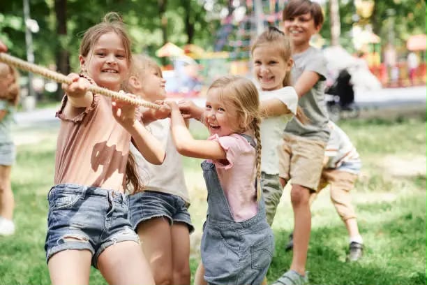 Kinder toben und schaukeln auf dem Spielplatz